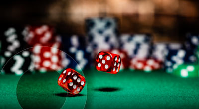 A bouncing pair of dice infront of a pile of poker chips