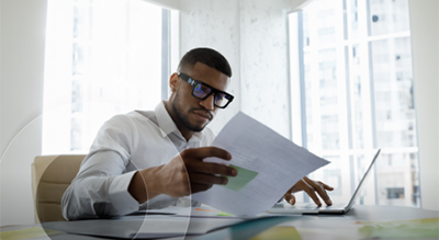 A person in deep thought reading a document in their hands