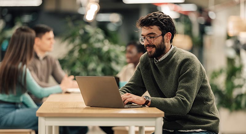 An employee works in an office on a laptop